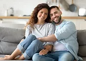 man and woman hugging while sitting on the sofa