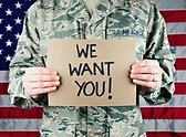 a man in military uniform holding a carboard sign
